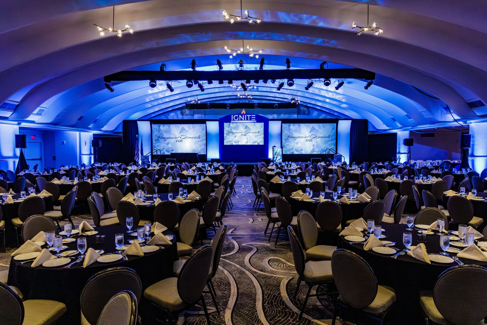 Full ballroom production with stage screens and lighting