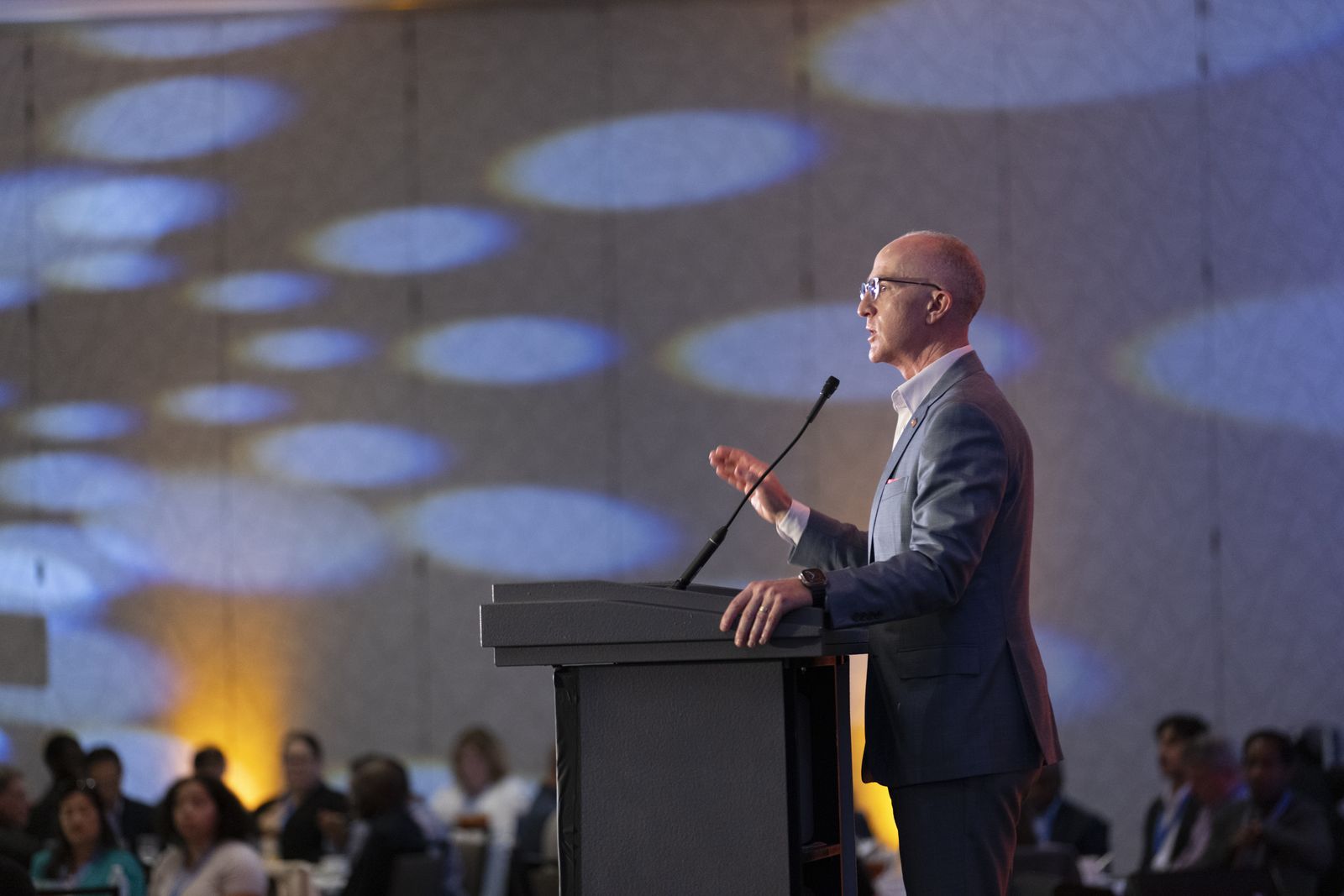 Keynote speaker at podium with custom stage lighting